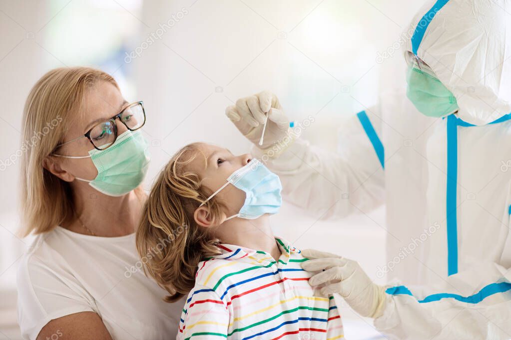 Coronavirus nasal swab test for kids. Doctor taking saliva sample for covid-19 diagnostics of child. Little boy patient in hospital. Protective hazmat suit for nurse and medical staff. Virus outbreak.