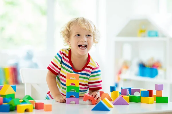 孩子玩彩色玩具块 小男孩用方块玩具建造塔楼 幼儿教育和创意玩具和游戏 婴儿在白色的卧室里用彩虹砖 在家的儿童 — 图库照片