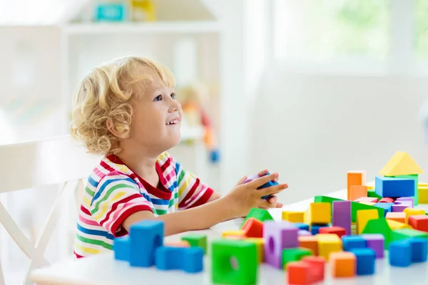 カラフルなおもちゃのブロックで遊んでいる子供 ブロックのおもちゃの小さな男の子の建物の塔 子供のための教育的で創造的なおもちゃやゲーム 虹レンガ付きの白い寝室の赤ちゃん 家にいる子供 — ストック写真