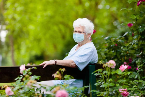 Senior woman wearing face mask during corona virus and flu outbreak. Disease and illness protection. Surgical masks for coronavirus prevention. Sick elderly patient coughing. Ill person.