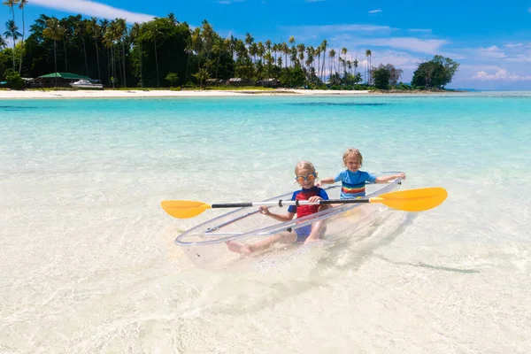 子供たちは海でカヤック 熱帯の海でカヤックの子供たち 若い子供とのアクティブな休暇 美しいビーチでカヌーの中の小さな男の子と女の子 子供との休日の活動 家族の水の楽しみ — ストック写真