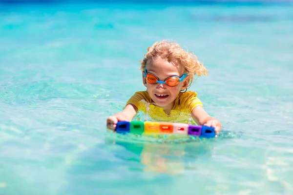 熱帯のビーチでサーフィンをする子供 アジアの家族の夏休み 子供たちは海水で泳ぐ サーフボードの子供だ エキゾチックな海で泳いでいる男の子 子供と一緒に旅行する 水とビーチスポーツ — ストック写真