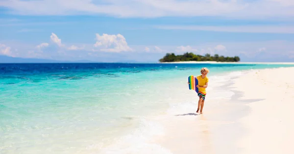 熱帯のビーチでサーフィンをする子供 アジアの家族の夏休み 子供たちは海水で泳ぐ サーフボードの子供だ エキゾチックな海で泳いでいる男の子 子供と一緒に旅行する 水とビーチスポーツ — ストック写真