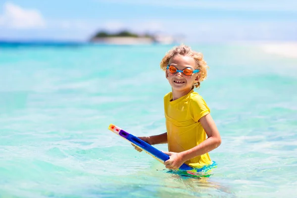 熱帯のビーチでサーフィンをする子供 アジアの家族の夏休み 子供たちは海水で泳ぐ サーフボードの子供だ エキゾチックな海で泳いでいる男の子 子供と一緒に旅行する 水とビーチスポーツ — ストック写真