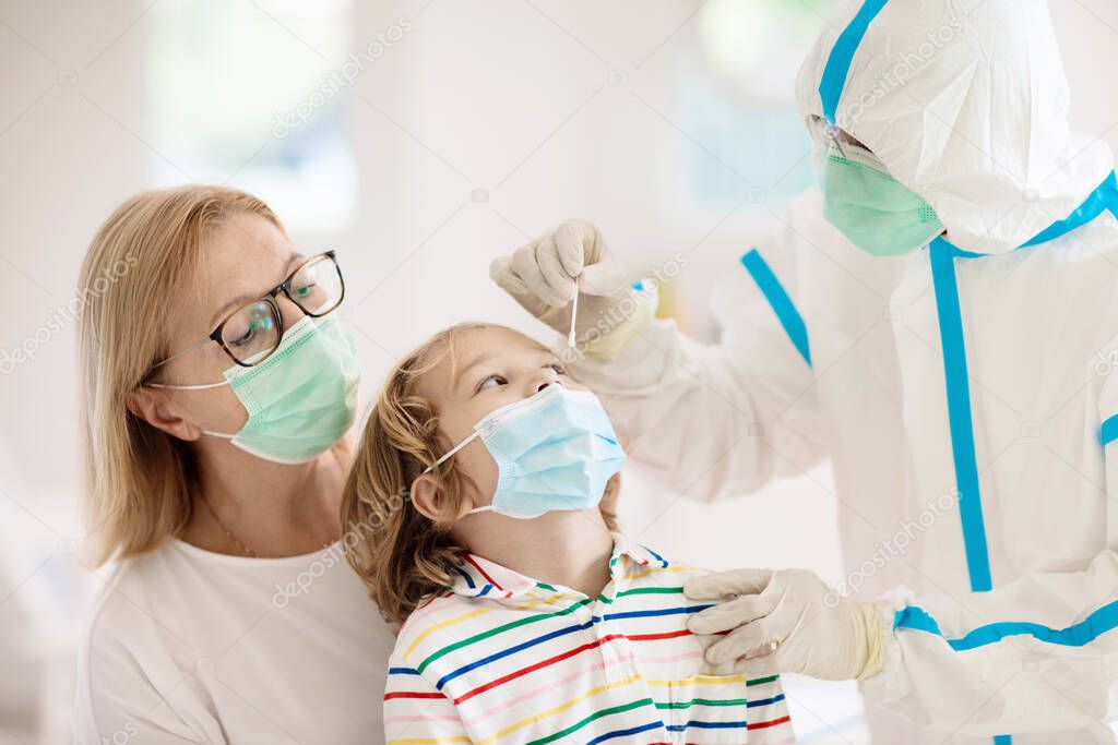 Coronavirus nasal swab test for kids. Doctor taking saliva sample for covid-19 diagnostics of child. Little boy patient in hospital. Protective hazmat suit for nurse and medical staff. Virus outbreak.