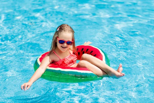수영장에서 수박을 부풀릴 수있는 고리를 가진아이 소녀는 휴양지 수영장에서 수영을 — 스톡 사진