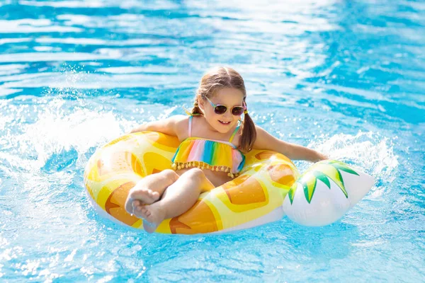 膨脹可能なパイナップルおもちゃのリングを持つ子供はプールに浮かぶ 小さな女の子は 熱帯リゾートの屋外プールで泳いだりダイビングを学ぶ 子供たちと一緒に泳ぐ 子供のための健康的なスポーツ 水遊び — ストック写真