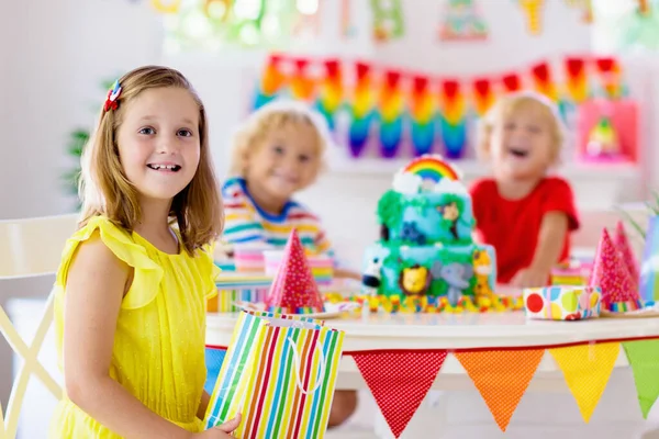 子供の誕生日パーティー ケーキの上にキャンドルを吹いて ジャングルのテーマのお祝いにプレゼントを開きます 子供向けのケーキデザート 男の子と女の子は誕生日を祝う 子供への贈り物とお菓子 — ストック写真