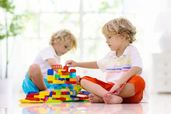 カラフルなおもちゃのブロックで遊ぶ子供 子供たちはプラスチックレンガで遊ぶ 少年の建物の塔と宇宙船 子供のための教育玩具 就学前または幼稚園の教室 家で子供 — ストック写真