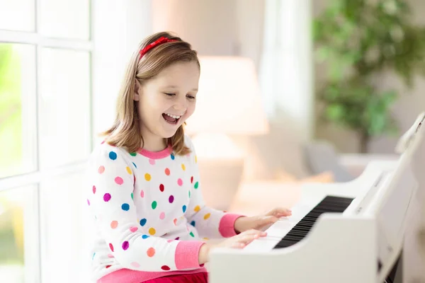 孩子弹钢琴 孩子们弹奏音乐 儿童的经典教育 艺术课 小女孩在白色数字键盘 年轻学生的乐器 学校或家里的音乐课 — 图库照片