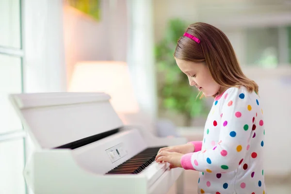 孩子弹钢琴 孩子们弹奏音乐 儿童的经典教育 艺术课 小女孩在白色数字键盘 年轻学生的乐器 学校或家里的音乐课 — 图库照片