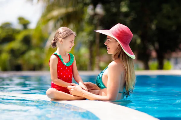 妈妈和孩子在游泳池 妈妈和孩子在热带度假胜地游泳 夏天海滩度假时 年轻的女人和穿着红色泳衣头戴红色帽子的小女孩 有子女家庭的假期和旅行 — 图库照片