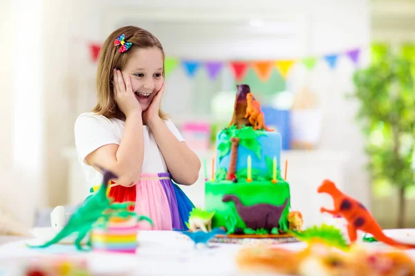 Fiesta Cumpleaños Niños Pastel Temático Dinosaurios Niña Soplando Velas Abriendo —  Fotos de Stock