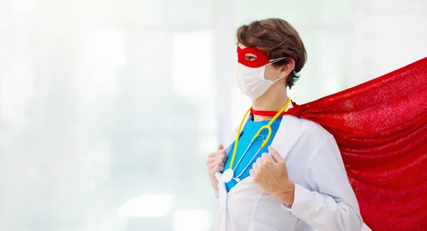 Doctor or nurse wearing surgical face mask in super hero cape. Medical staff during coronavirus outbreak. Hero power for clinic and hospital personal.