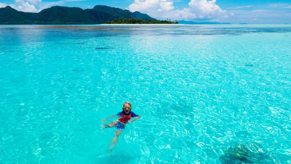 子供のシュノーケリング ビーチの楽しみ エキゾチックな島の家族の夏休みに熱帯の海でシュノーケリングをする子供たち マスクとフィン付きの子供 家族旅行 子供はダイビングを学ぶ ダイビング休暇 — ストック写真