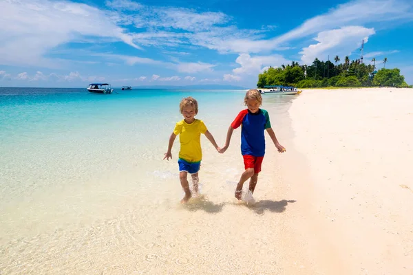 孩子们在热带海滩玩耍 孩子们在暑假时在海上游泳和玩耍 沙子和水的乐趣 防晒幼儿 小男孩和小女孩在海滨跑来跑去 — 图库照片