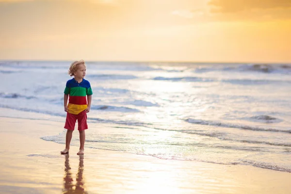 海のビーチで遊んでいる子供 子供は日没時に波に飛び込む 家族のための海の休暇 夏休みに異国の島を走る少年 — ストック写真