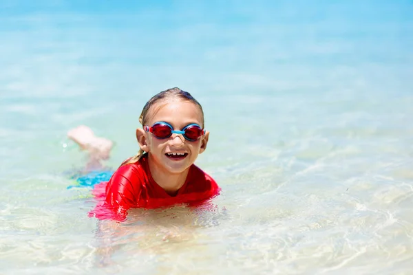 子供たちは走り 熱帯のビーチで遊びます 子供たちは夏休みに海で泳いだりジャンプしたりします 砂と水の楽しさ 幼い子供のための太陽の保護 海の岸を走って飛び跳ねる少年 — ストック写真