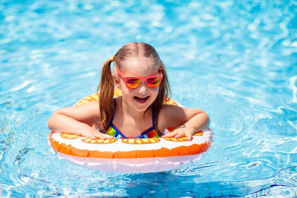 子供のプールおもちゃのリングに浮かんでいます 子供たちは泳ぐ 子供のためのカラフルな黄色のフロート トロピカルリゾートで家族の夏休みを楽しんでいる小さな女の子 ビーチや水のおもちゃ 太陽の保護 — ストック写真