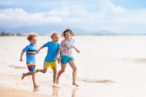 孩子们在热带海滩玩耍 孩子们在暑假时在海上游泳和玩耍 沙子和水的乐趣 防晒幼儿 小男孩和小女孩在海滨跑来跑去 — 图库照片