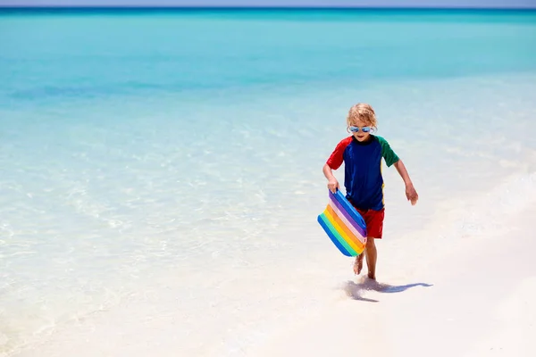熱帯のビーチでサーフィンをする子供 アジアの家族の夏休み 子供たちは海水で泳ぐ サーフボードの子供だ エキゾチックな海で泳いでいる男の子 子供と一緒に旅行する 水とビーチスポーツ — ストック写真