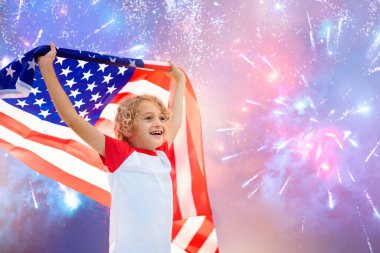 Amerikan ailesi 4 Temmuz 'u kutluyor. Independence Day havai fişeklerini izleyen insanlar Amerikan bayrağı taşıyor. Gururlu Amerikan çocukları tezahürat ve kutlama yapıyor. Amerikan sembollü çocuk. Ulusal bayram partisi.