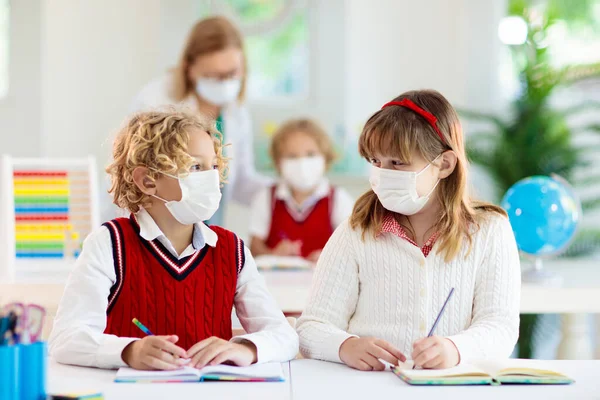 在学校课堂上戴口罩的孩子 在科罗纳韦病毒关闭后 孩子们又回到了学校 Covid 19大流行病中的幼儿 安全和病毒传播预防 戴口罩的学生社会疏离 — 图库照片