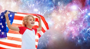 Amerikan ailesi 4 Temmuz 'u kutluyor. Independence Day havai fişeklerini izleyen insanlar Amerikan bayrağı taşıyor. Gururlu Amerikan çocukları tezahürat ve kutlama yapıyor. Amerikan sembollü çocuk. Ulusal bayram partisi.