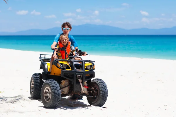 ティーンエイジャーと彼の弟は熱帯のビーチでクワッドバイクに乗っています 四輪駆動のアクティブな10代の少年 全地形車両に乗る 海の砂の砂丘でモータースポーツを渡ります 子供の夏休み活動 — ストック写真