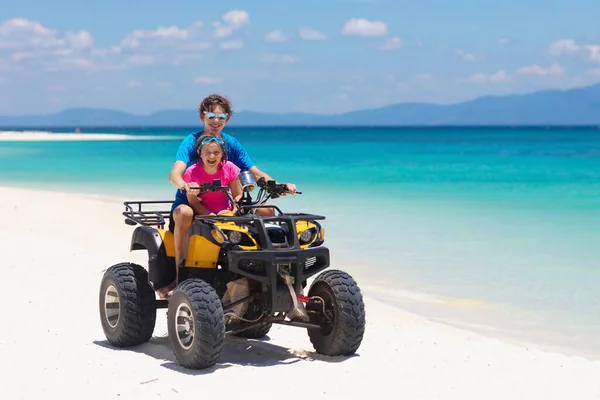 ティーンエイジャーと彼の弟は熱帯のビーチでクワッドバイクに乗っています 四輪駆動のアクティブな10代の少年 全地形車両に乗る 海の砂の砂丘でモータースポーツを渡ります 子供の夏休み活動 — ストック写真