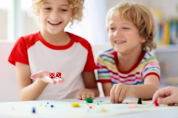 家庭在家里玩棋盘游戏 孩子们玩战略游戏 小男孩扔骰子 暑假的室内活动很有趣 兄弟姐妹的结合 教育玩具 朋友们享受游戏之夜 — 图库照片