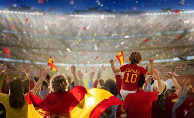 Stadyumdaki İspanya futbolu taraftarı. İspanyol taraftarlar futbol sahasında takımın maçını izliyorlar. Bayrak taşıyan ve ulusal forma giyen bir grup destekçi İspanya için tezahürat yapıyor. Şampiyonluk maçı. Hadi Espana.!