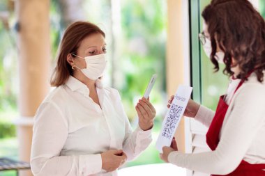 Cep telefonundaki dijital covid-19 aşı sertifikası. Coronavirus aşılanmış insanlar restoran girişindeki QR kodunu tarıyor. Negatif test, tamamlanmış aşı ve güvenli yolculuk için dokunulmazlık.