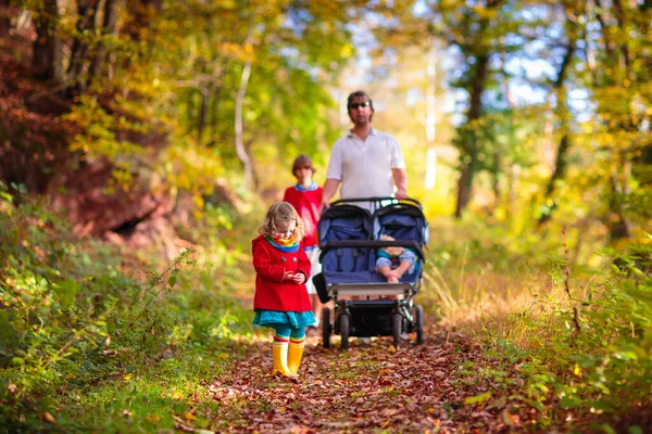 带着双人推椅远足的人 爸爸和孩子们在散步 与幼儿一起进行健康的户外活动 与新生儿和幼儿一起运动和锻炼 爸爸和孩子在公园里远足 — 图库照片