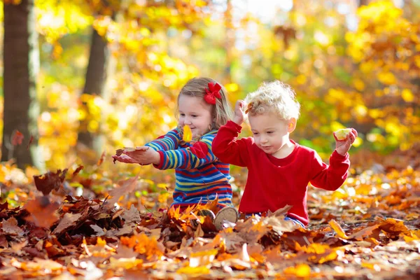 秋天公园里的孩子黄叶小女孩 小孩在玩金黄色的落叶 孩子们在户外玩耍 孩子们在森林里远足 十月阳光灿烂的一天 孩子们在枫树下玩耍 — 图库照片