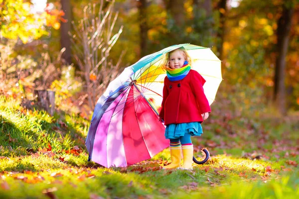 雨の中で遊んでいる子供 傘やレインブーツを着た子供たちは 豪雨の中屋外で遊ぶ 泥だらけの水たまりに飛び込む少女 子供たちは雨の秋の天気で楽しい 嵐の中を走る子供 — ストック写真