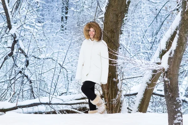 Beautiful young woman walking in a snowy park — Stock Photo, Image