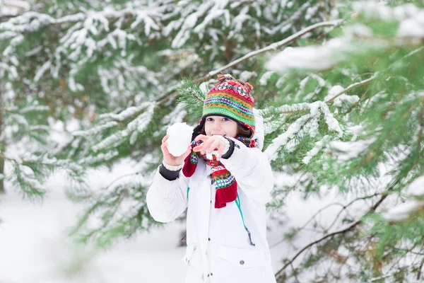 Söt skrattande pojke spela snö boll kamp i en snöig skog — Stockfoto