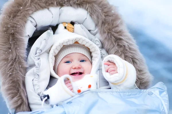 Baby in de kinderwagen in een winter park — Stockfoto