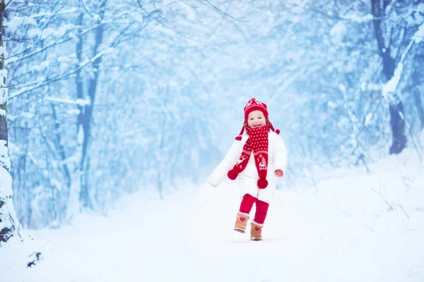 Μικρό κορίτσι που τρέχει σε ένα χιονισμένο πάρκο — Φωτογραφία Αρχείου