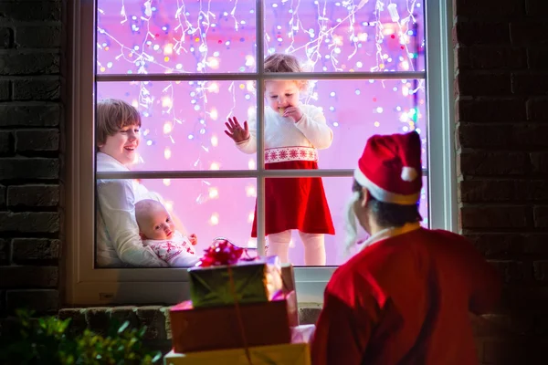 Kinderen kijken naar santa op kerstavond — Stockfoto
