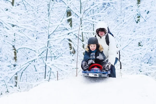 Little boy sledding down a hill with his father — Stock Photo, Image