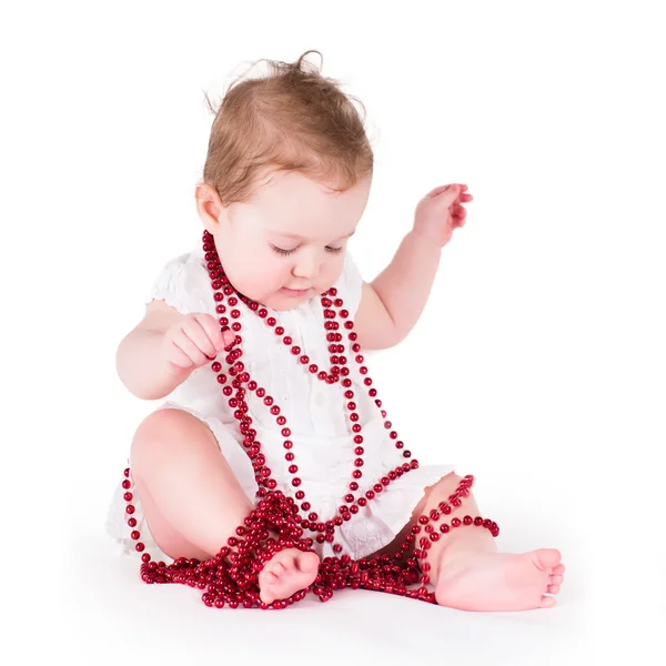 Chica jugando con perlas rojas — Foto de Stock