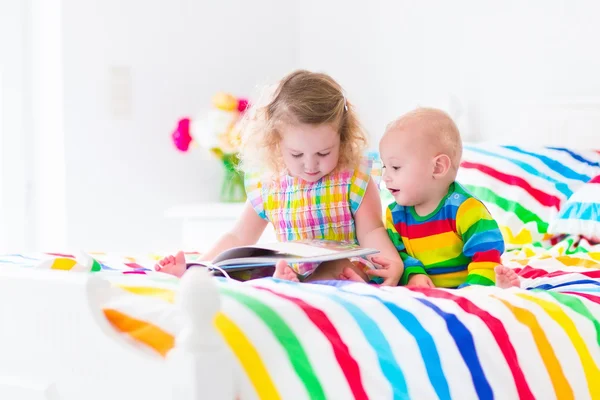 iki çocuğun yatakta kitap okuma