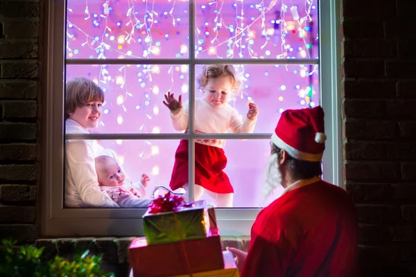 Barnen tittar på santa på julafton — Stockfoto