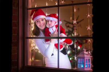 Anne ve bebek Noel Baba gibi giyinmiş
