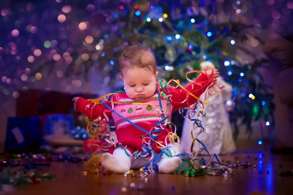 Baby unter dem Weihnachtsbaum — Stockfoto