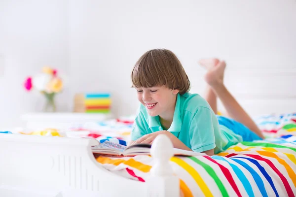 Boy membaca buku di tempat tidur — Stok Foto