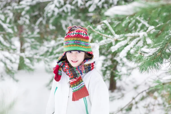 Porträtt av en söt barn leker i en snöig skog — Stockfoto