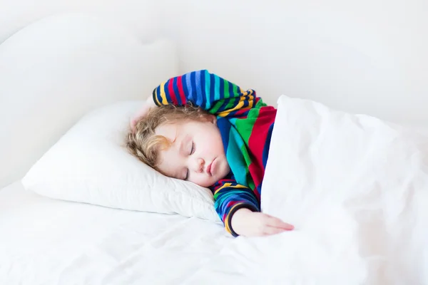Lustiges Kleinkind, das in einem weißen Bett schläft — Stockfoto